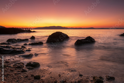 Beautiful seascape wave move on the rock at sunset