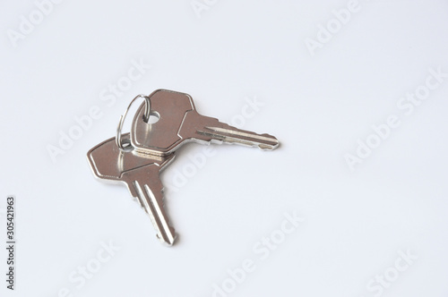 Grey metal keys on white background. Keys for the door lock. Two keys to the front door.