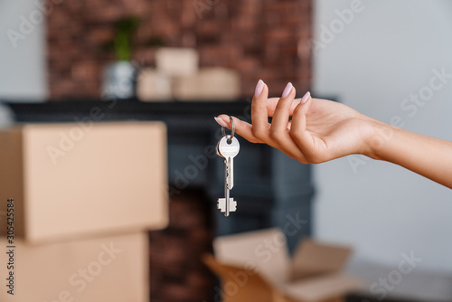 House key in womans hands, concept of moving or rent appartment photo