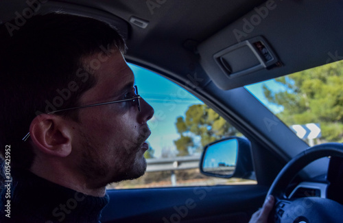man driving looking at the road with sunglasses on a winter's day