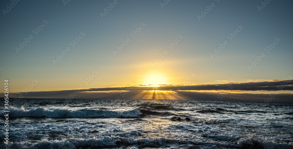 Rough sea and shining sun at sunset