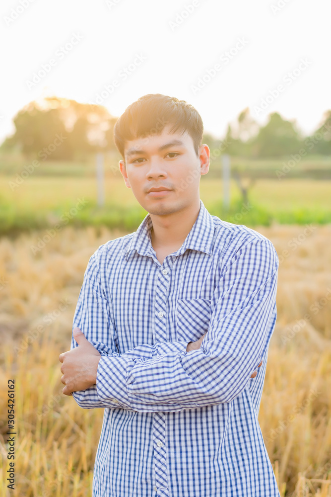 Portrait of a handsome young farmer standing in a natural background shirt at sunset