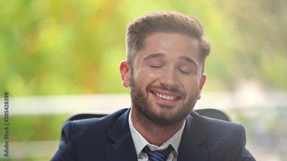 young businessman smiling while looking at camera young businessman smiling while looking at camera