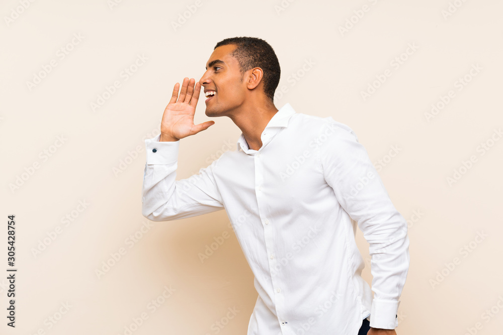 Young handsome brunette man over isolated background shouting with mouth wide open to the lateral Young handsome brunette man over isolated background shouting with mouth wide open to the lateral