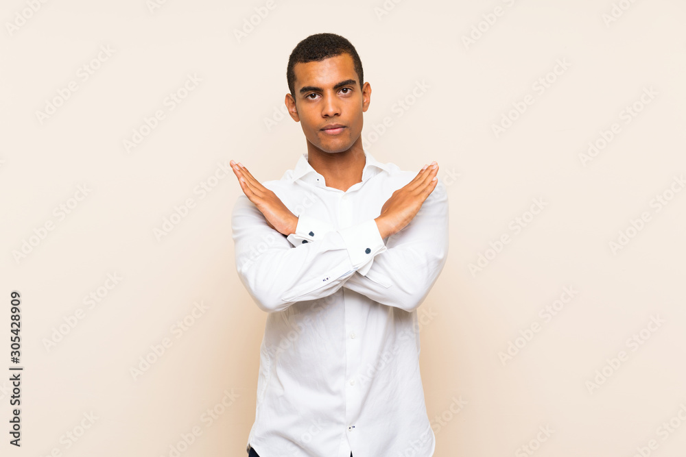 Young handsome brunette man over isolated background making NO gesture Young handsome brunette man over isolated background making NO gesture