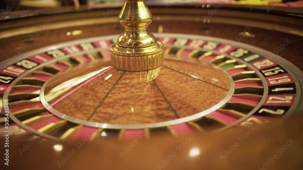 wooden roulette spinning in casino, close up croupier hands, luxury entertainment ,ball spinning around wooden roulette spinning in casino, close up croupier hands, luxury entertainment ,ball spinning around