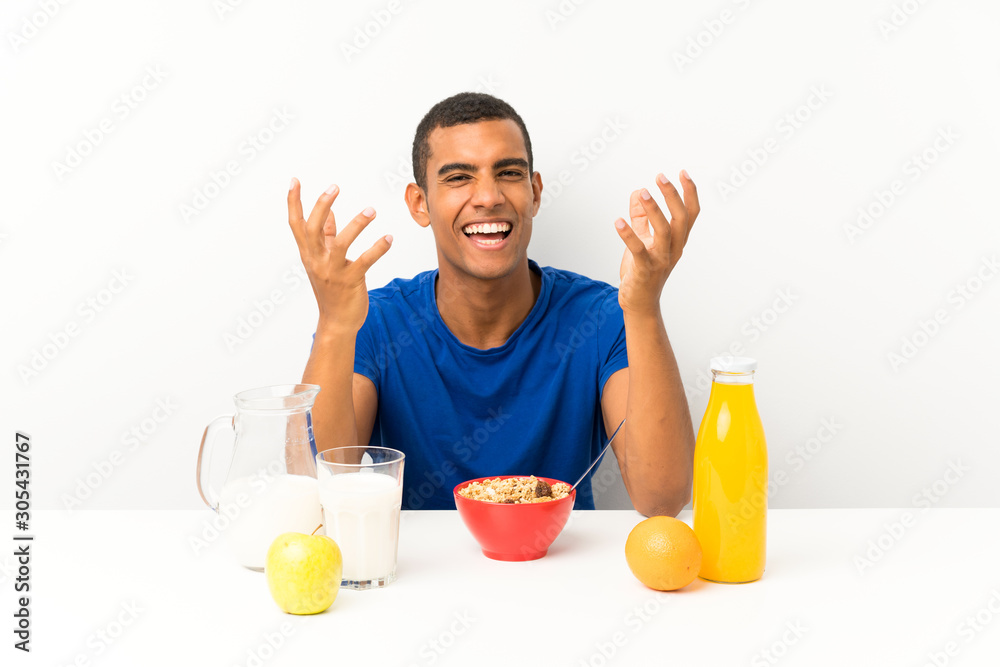 Young man having breakfast in a table unhappy and frustrated with something Young man having breakfast in a table unhappy and frustrated with something