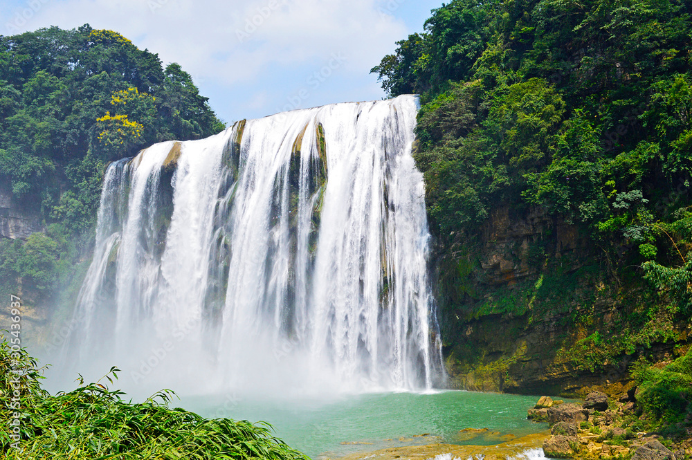Fototapeta premium China Guizhou Huangguoshu Waterfall in Summer. One of the largest waterfalls in China and East Asia, classified as a AAAAA scenic area by the China National Tourism Administration.