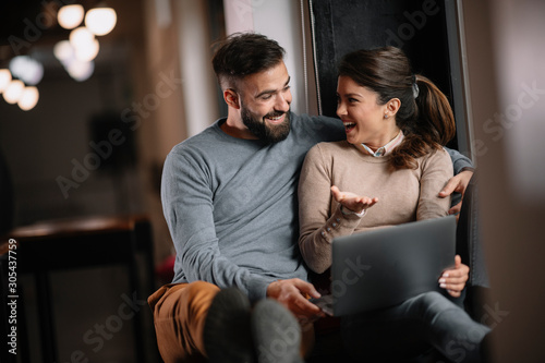 Young happy couple. Boyfriend and girlfriend using laptop together. 