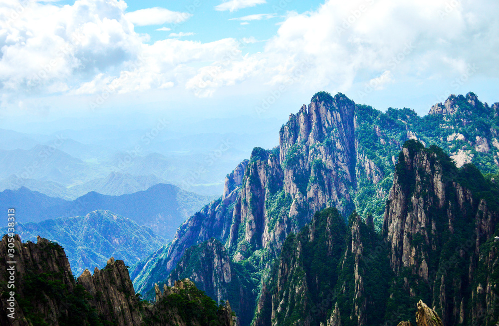 Peaks of Huangshan (Yellow Mountain) under Cloud and Blue Sky. Located at Anhui province China, Huangshan is a UNESCO World Heritage Site and one of China's major tourist destinations.
