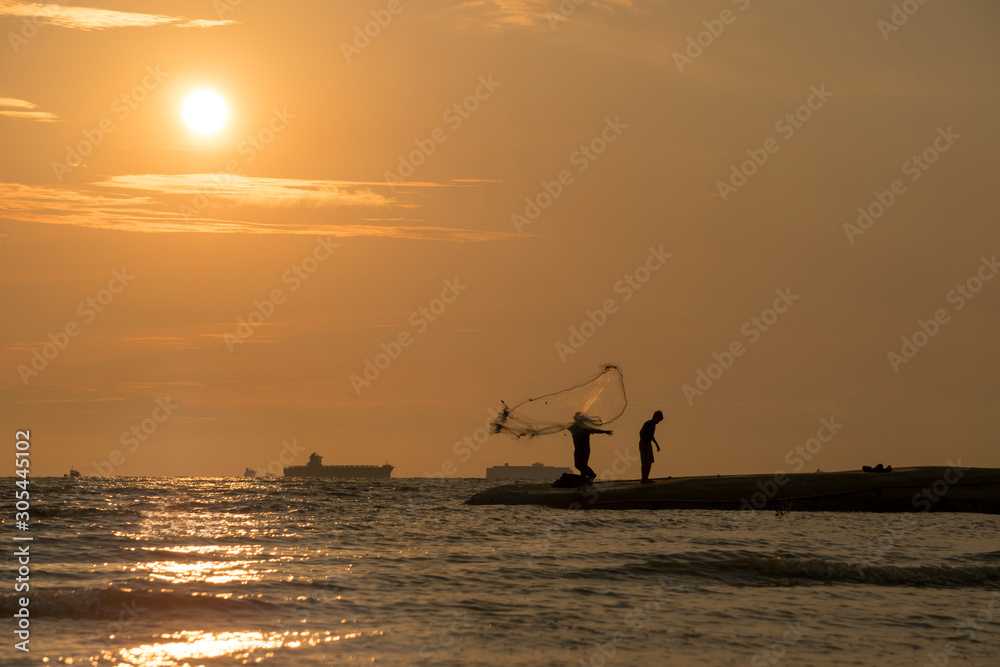 Beautiful sunset nature background, unknown fisherman with net fish on beach. Father and son fishing. Family bond concept.