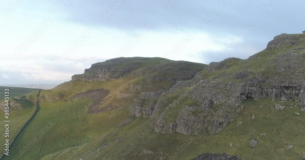 Flying above rocky hills in Yorkshire Dales in England.