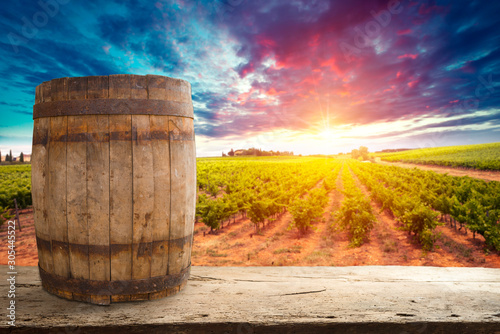 Red wine with barrel on vineyard in green Tuscany, Italy