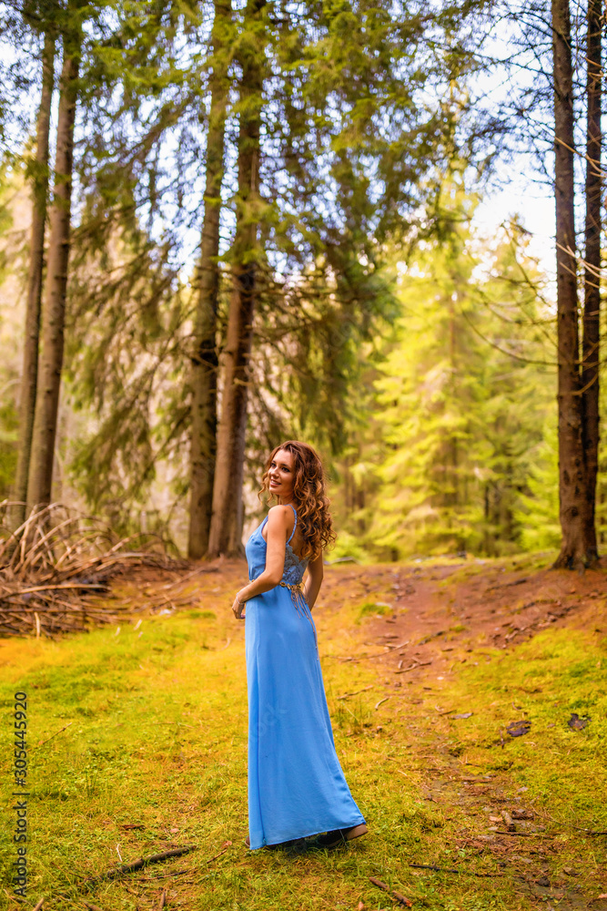 Beautiful woman in blue dress in the forest in autumn day Beautiful woman in blue dress in the forest in autumn day