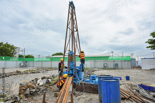 Construction workers drilling obtaining soil samples field for geological logging, analysis and testing, soil investigation before design pile tip for construction site.