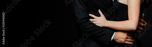 panoramic shot of man hugging young woman isolated on black