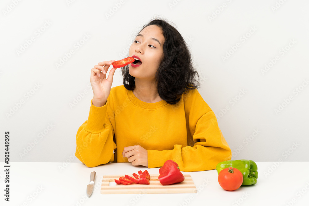 Young asian girl with vegetables in a table Young asian girl with vegetables in a table