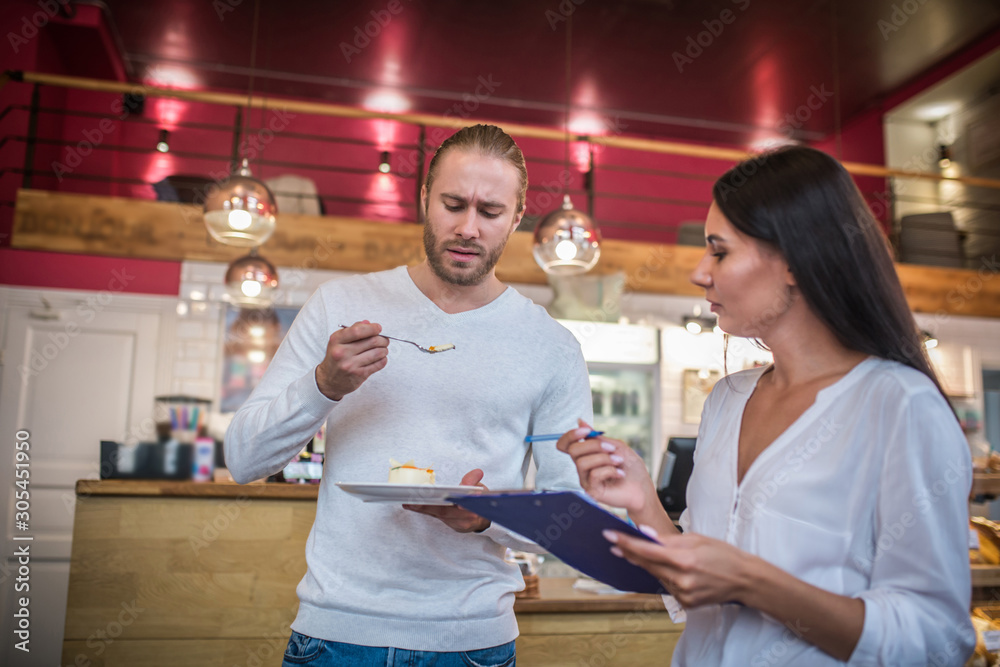 Obraz premium Couple owning cafeteria feeling not really satisfied with the dessert