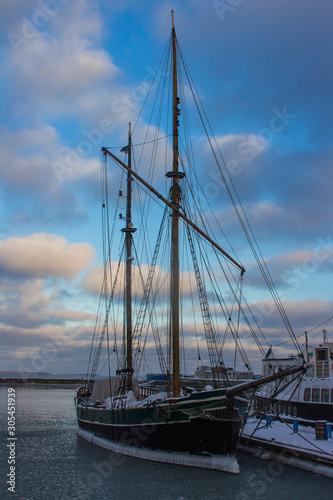 Fototapeta Naklejka Na Ścianę i Meble -  Historic sailing ship frozen in the water near the pier in Tallinn. Estonia