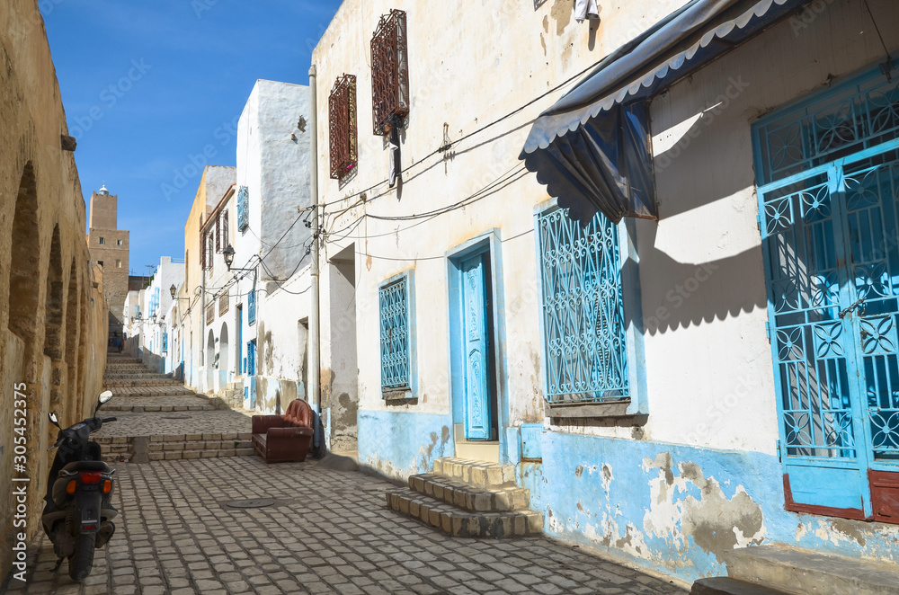 Typical street in the medieval medina of Sousse, Tunisia. The Kasbah tower is visible in the background.