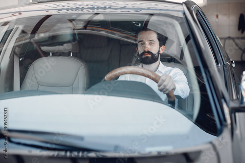 Man buying the car. Businessman in a car salon