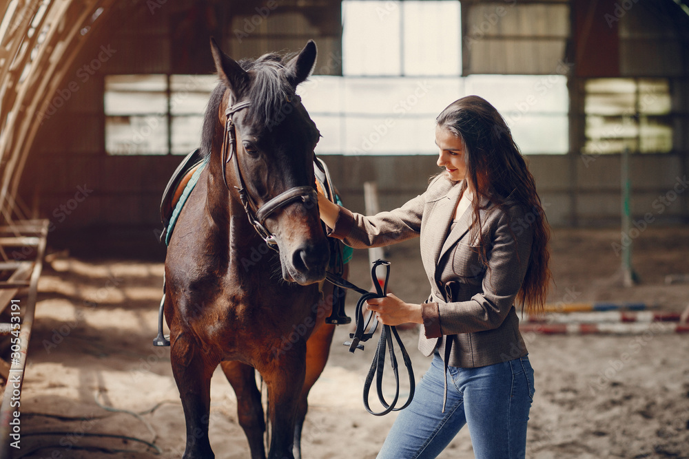 Obraz premium Woman standing with a horse. Lady in a brown jacket