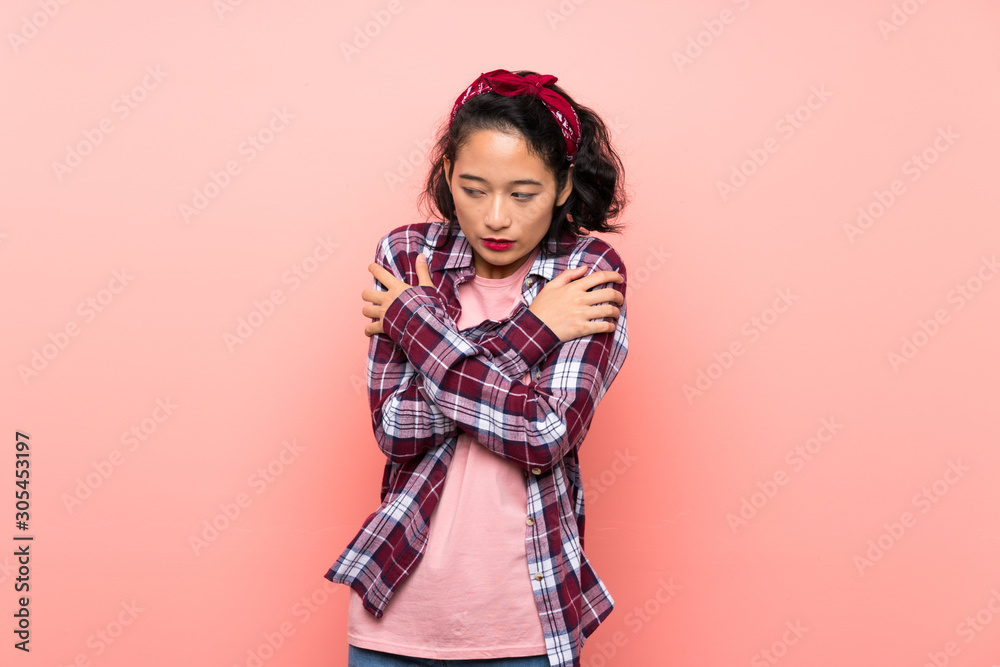 Asian young woman over isolated pink background freezing Asian young woman over isolated pink background freezing