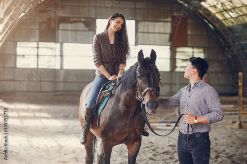 Couple on a ranch. Pair standing with a horse. Girl with her boyfriend © prostooleh