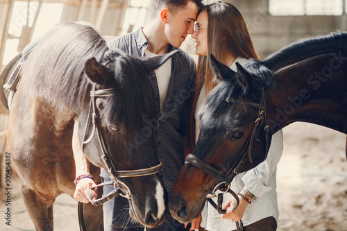 Couple on a ranch. Pair standing with a horse. Girl with her boyfriend