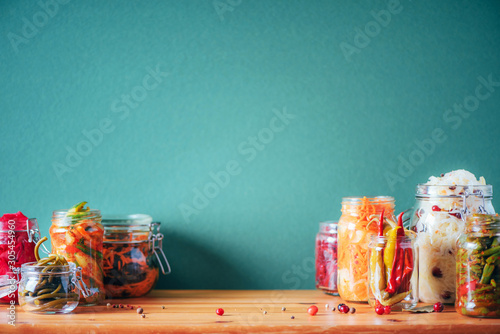 Probiotics food background. Korean carrot, kimchi, beetroot, sauerkraut, pickled cucumbers in glass jars. Winter fermented and canning food concept. Banner with copy space photo