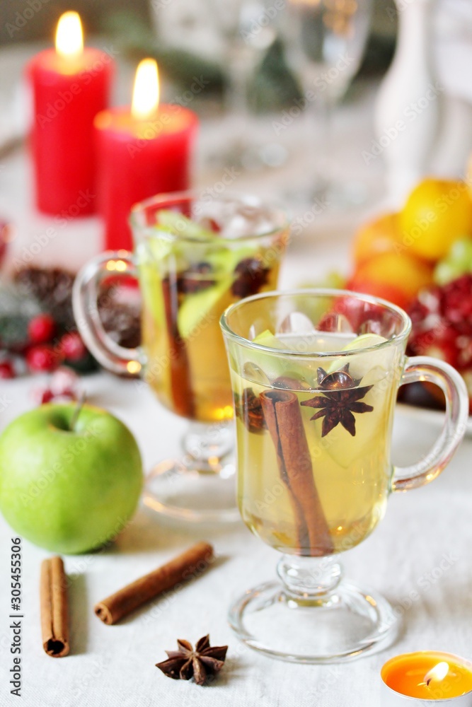 christmas hot cider. hot winter drink Cranberry Apple Cider Punch. Garnish with apples, oranges, and cranberries. hot apple cider with spices on a festive table on Christmas or New Year. christmas hot cider. hot winter drink Cranberry Apple Cider Punch. Garnish with apples, oranges, and cranberries. hot apple cider with spices on a festive table on Christmas or New Year.