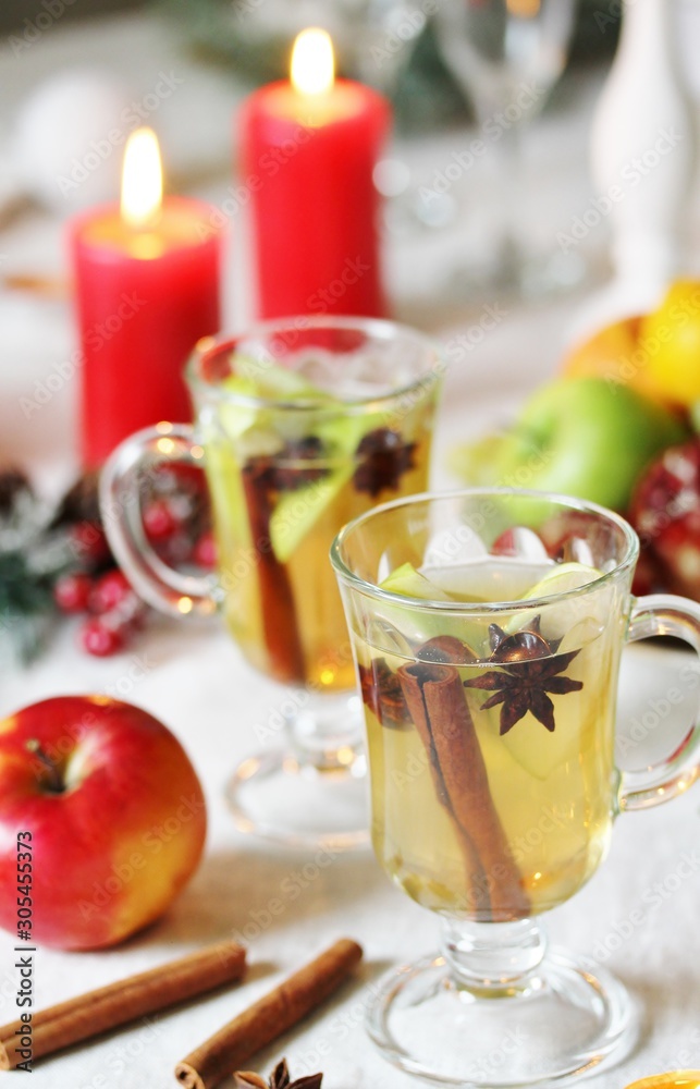 christmas hot cider. hot winter drink Cranberry Apple Cider Punch. Garnish with apples, oranges, and cranberries. hot apple cider with spices on a festive table on Christmas or New Year. christmas hot cider. hot winter drink Cranberry Apple Cider Punch. Garnish with apples, oranges, and cranberries. hot apple cider with spices on a festive table on Christmas or New Year.