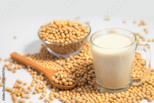 Soy milk pouring in glass and soy bean or soya bean . Alternative Soy milk healthy concept.
