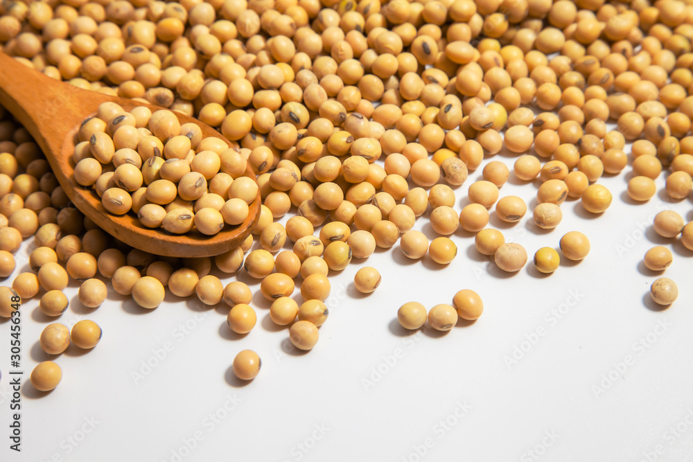 Soybeans background . Dry Soy bean or soya bean in a bowl with some soybeans in wooden spoon on white background Soybeans background . Dry Soy bean or soya bean in a bowl with some soybeans in wooden spoon on white background