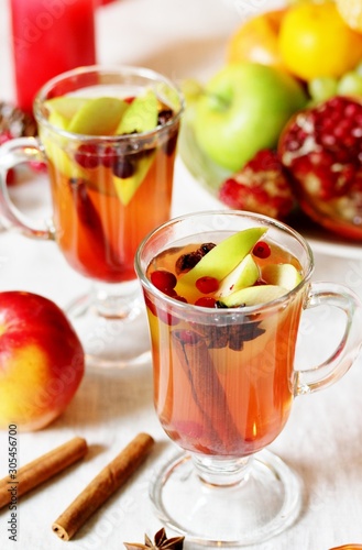 hot winter drink Cranberry Apple Cider Punch. Garnish with apples  oranges  and cranberries. hot apple cider with spices on a festive table on Christmas or New Year.