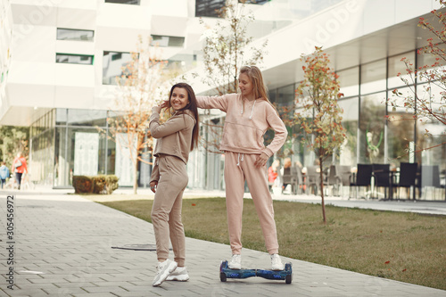 Women in a autumn park. Girl in a brown suits. Friends have fun with giroboard photo