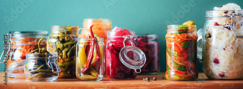 Probiotics food background. Korean carrot, kimchi, beetroot, sauerkraut, pickled cucumbers in glass jars. Winter fermented and canning food concept. Banner with copy space photo