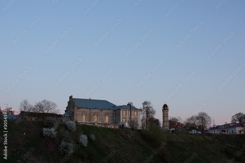 Sights and views of Grodno. Belarus. The building of a synagogue and a fire tower from the side of the ravine against the background of the evening sky.