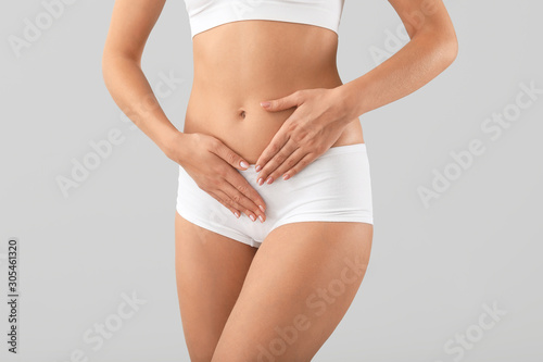 Young woman on grey background, closeup. Gynecology concept photo