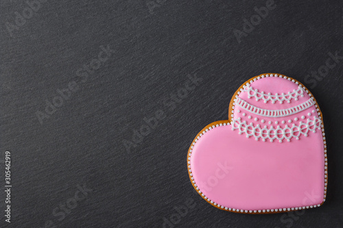 Pink cookie heart shaped with different patterns, black slate stone background
