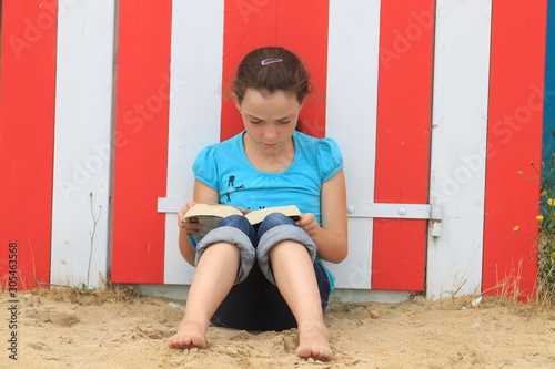 Jeune fille lisant à la plage