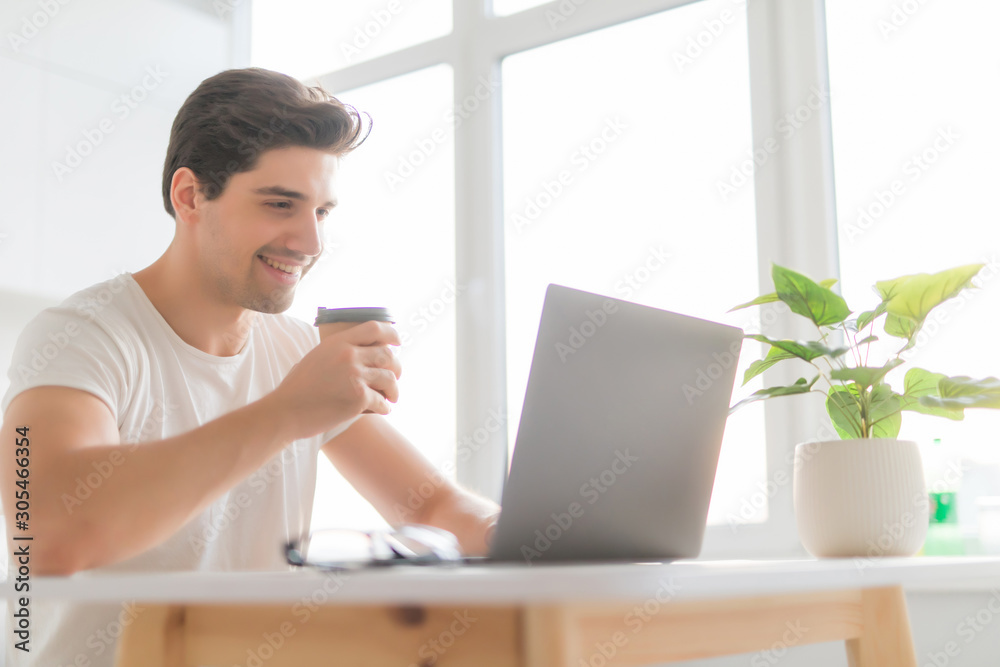 Portrait of handsome man sitting at table at home with laptop computer, smiling at camera. Portrait of handsome man sitting at table at home with laptop computer, smiling at camera.