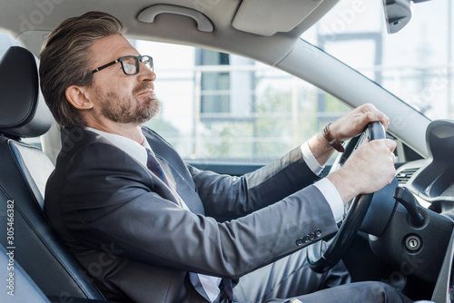 bearded ambassador holding steering wheel while driving car © LIGHTFIELD STUDIOS