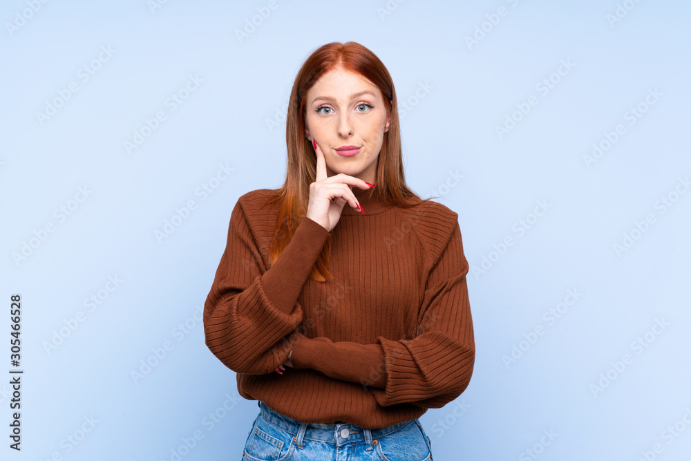 Young redhead woman over isolated blue background Looking front Young redhead woman over isolated blue background Looking front