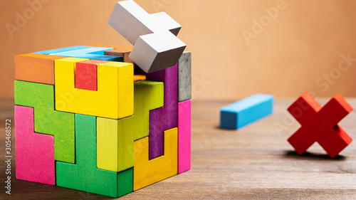 Bild auf Leinwand Missed items are seting in the colorful wooden cube puzzle on the brown table