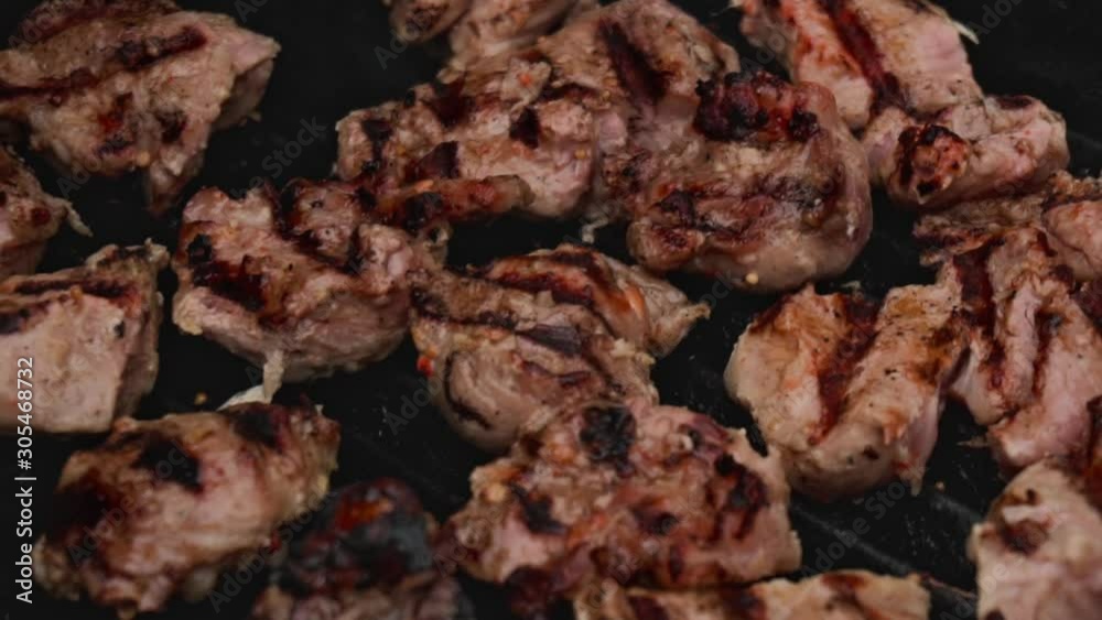 Pieces of pork beef meat are cooked on barbecue grill in open air in slow motion. Food and Catering. Traditional national marinated dish Shashlik or shish kebab is fried on bbq. Close up Pieces of pork beef meat are cooked on barbecue grill in open air in slow motion. Food and Catering. Traditional national marinated dish Shashlik or shish kebab is fried on bbq. Close up
