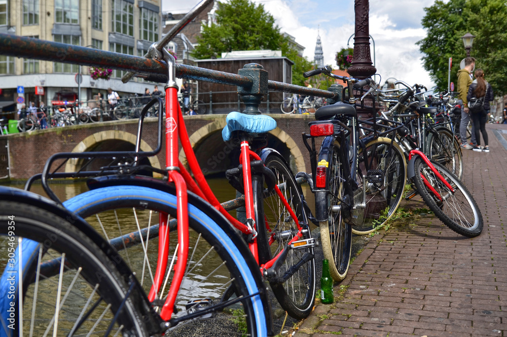 Amsterdam, Holland. August 2019. Bicycles parked along the canals are a symbol of the city. A bike with a red racing frame stands out among the others.