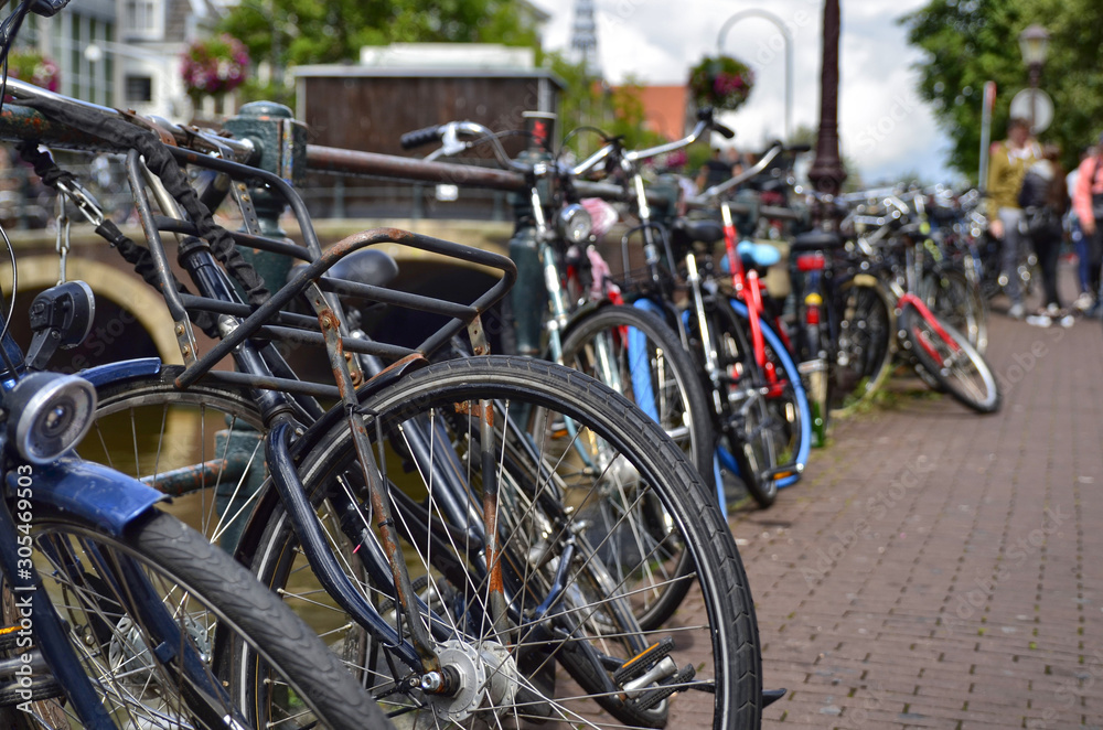 Obraz premium Amsterdam, Holland. August 2019. Bicycles parked along the canals are a symbol of the city. A bike with a red racing frame stands out among the others.
