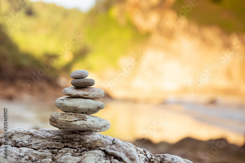 Piedras de distintos tamaños apiladas en forma piramidal junto al mar. photo