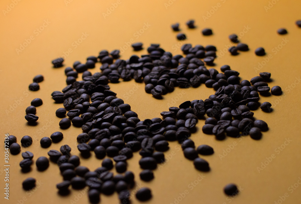 coffee beans on orange background with heart silhouette coffee beans on orange background with heart silhouette